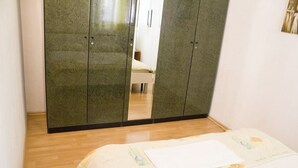 Ein Schlafzimmer mit einem Bett, einem Kleiderschrank und einem Spiegel.