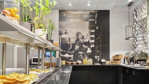A buffet setup with various food items and a large wall mural. - Connect hotel city (Stockholm)