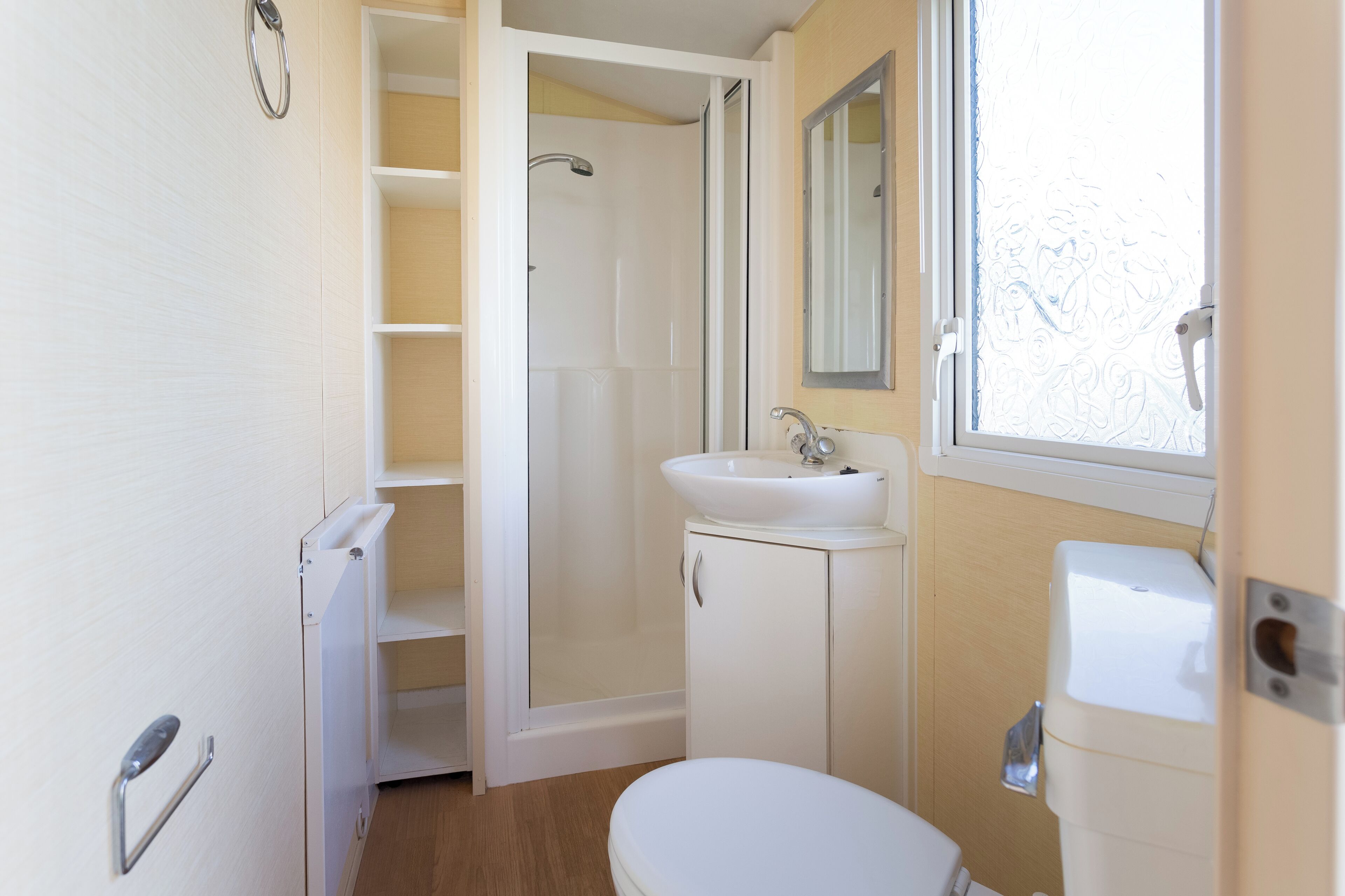 Un baño pequeño con inodoro, lavamanos y ducha.