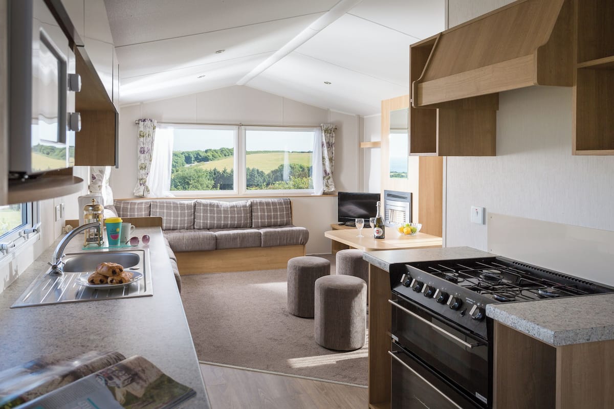 A modern kitchen with a stove, sink, and seating area with a view.
