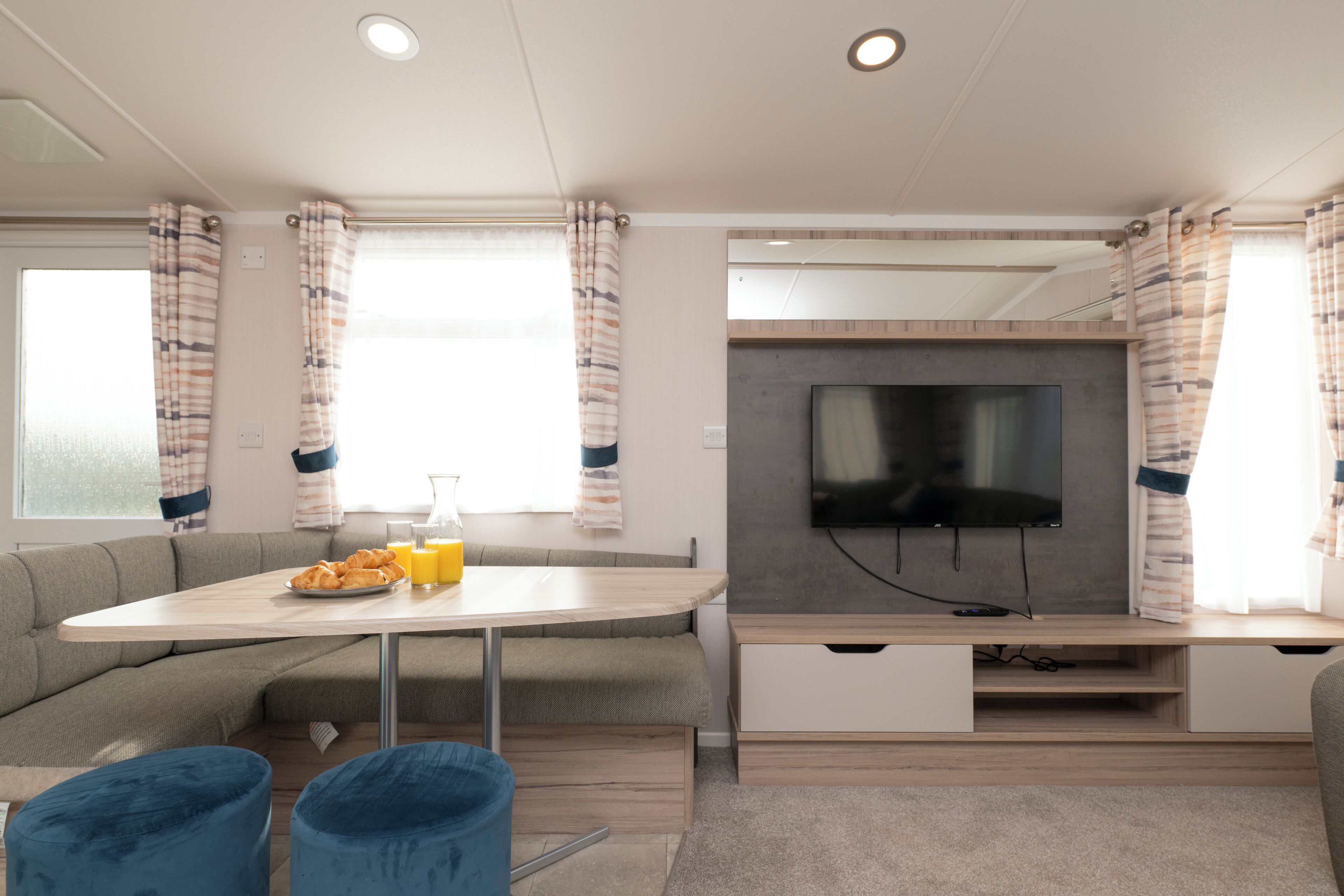 A modern living area with a sofa, a dining table, a TV, and a coffee table.