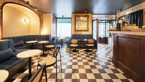 Ein Restaurant mit Schachbrettfußboden, Sitzbereichen und einer Bar.