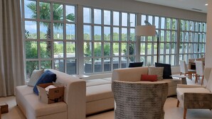 Un espacio habitable amplio con ventanas grandes, un sofá, una silla y una mesa.