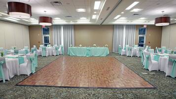 A conference room with a central stage, round tables, and chairs, all arranged for a meeting or event.