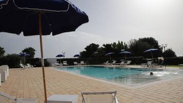 Alberca al aire libre por temporada y sombrillas en la alberca