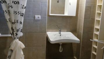 Ein Badezimmer mit Waschbecken, Spiegel und Fliesen.