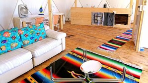 A tented accommodation with a sofa, a table with a bowl, colorful rugs, and a fan. - B&B Semaforo di Capo Sperone (Sant'Antioco)