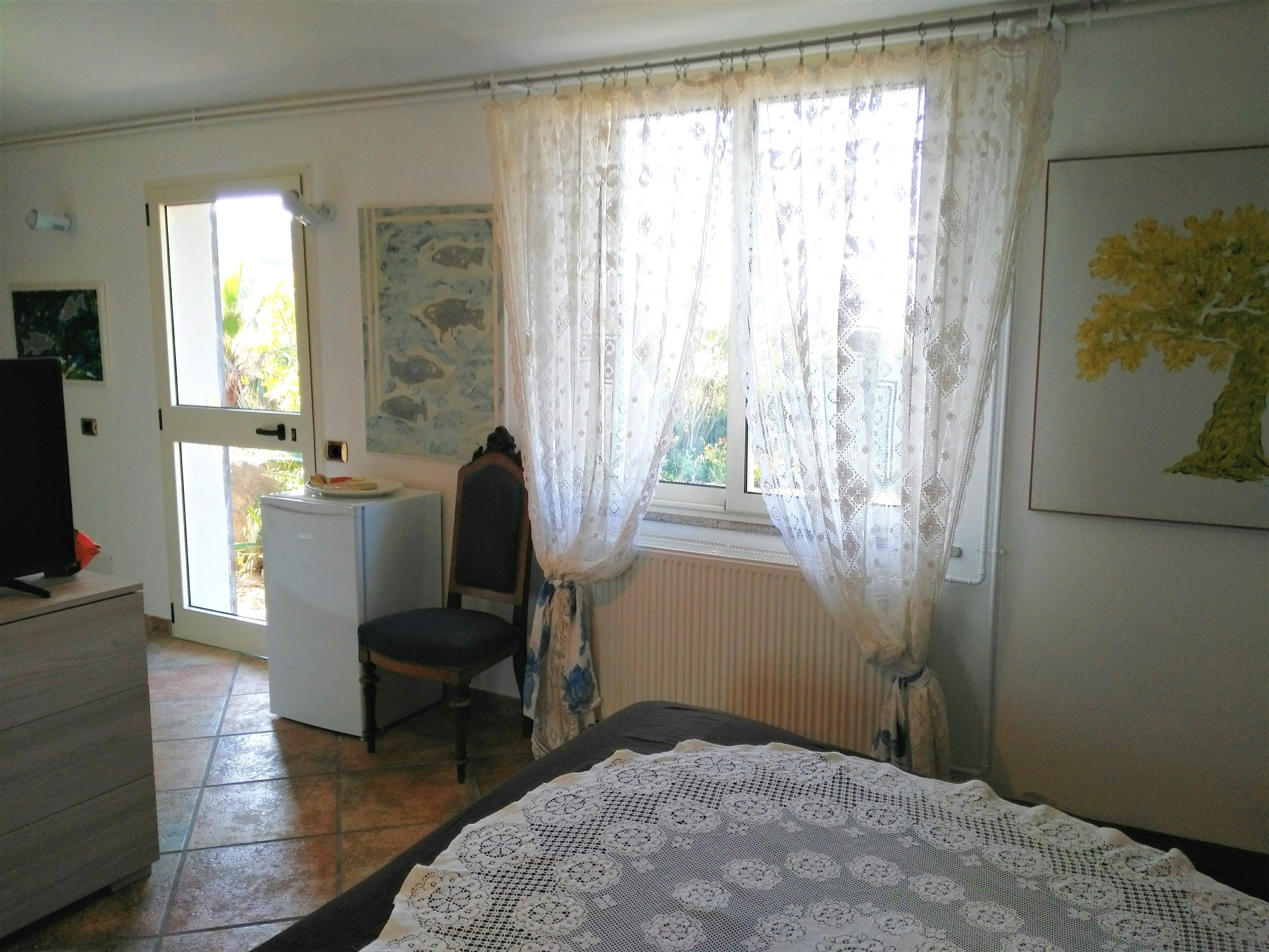 Una habitación con cama, escritorio, silla y radiador.