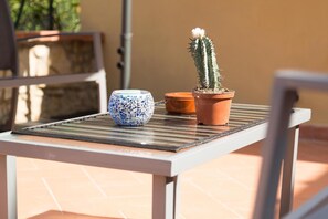 Een klein tafeltje met een cactus in een pot en een blauw-wit keramieken kom.