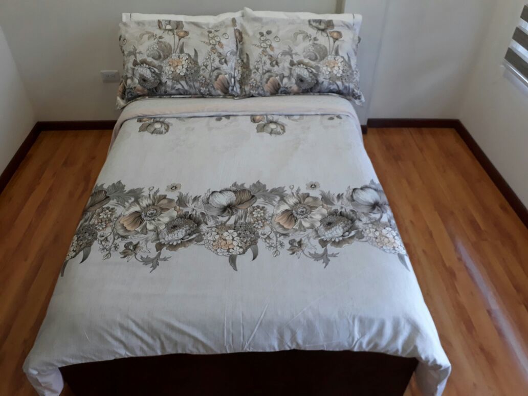 A bed with floral bedding and a matching pillow set.