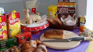 Un bufé de desayuno con diversas opciones de comida, incluyendo bollería, cereales y bebidas.