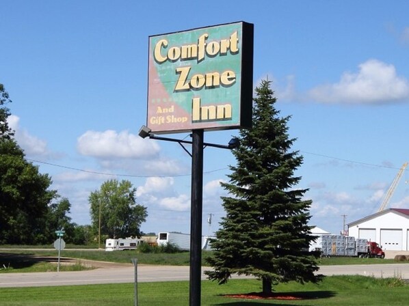 A sign for Comfort Zone Inn with a gift shop.