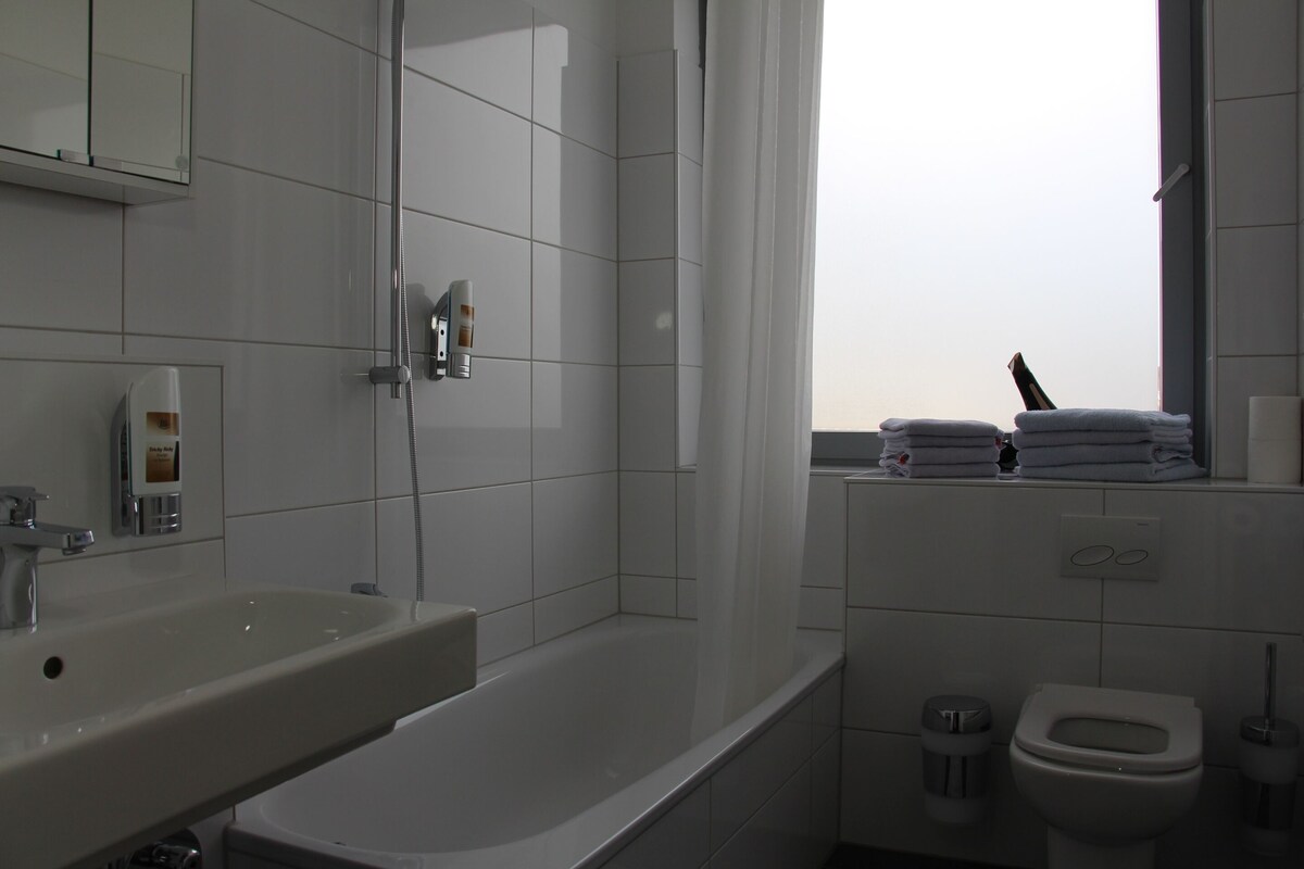 A modern bathroom with a bathtub, toilet, and sink.