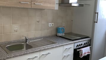 A kitchen with a stainless steel sink, a gas stove, and a built-in oven.