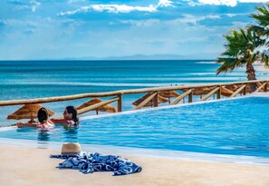 A poolside area with a wooden railing, a hat, and a towel on the sand. - TUI BLUE Palm Beach Hammamet - All Inclusive  (Hammamet)