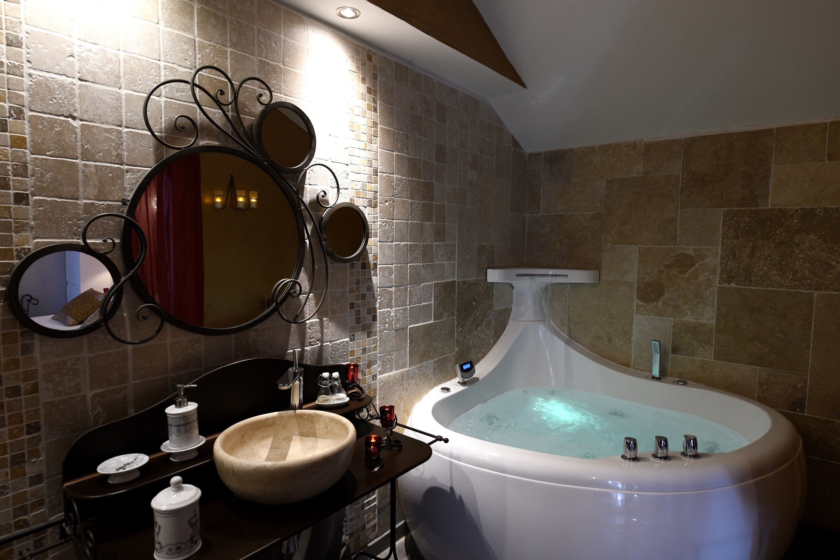 A bathroom with a freestanding bathtub, a large mirror, and a wooden vanity.