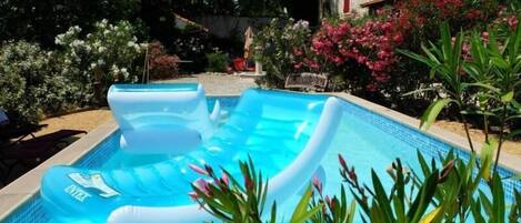 Alberca al aire libre, sombrillas en la alberca y camastros