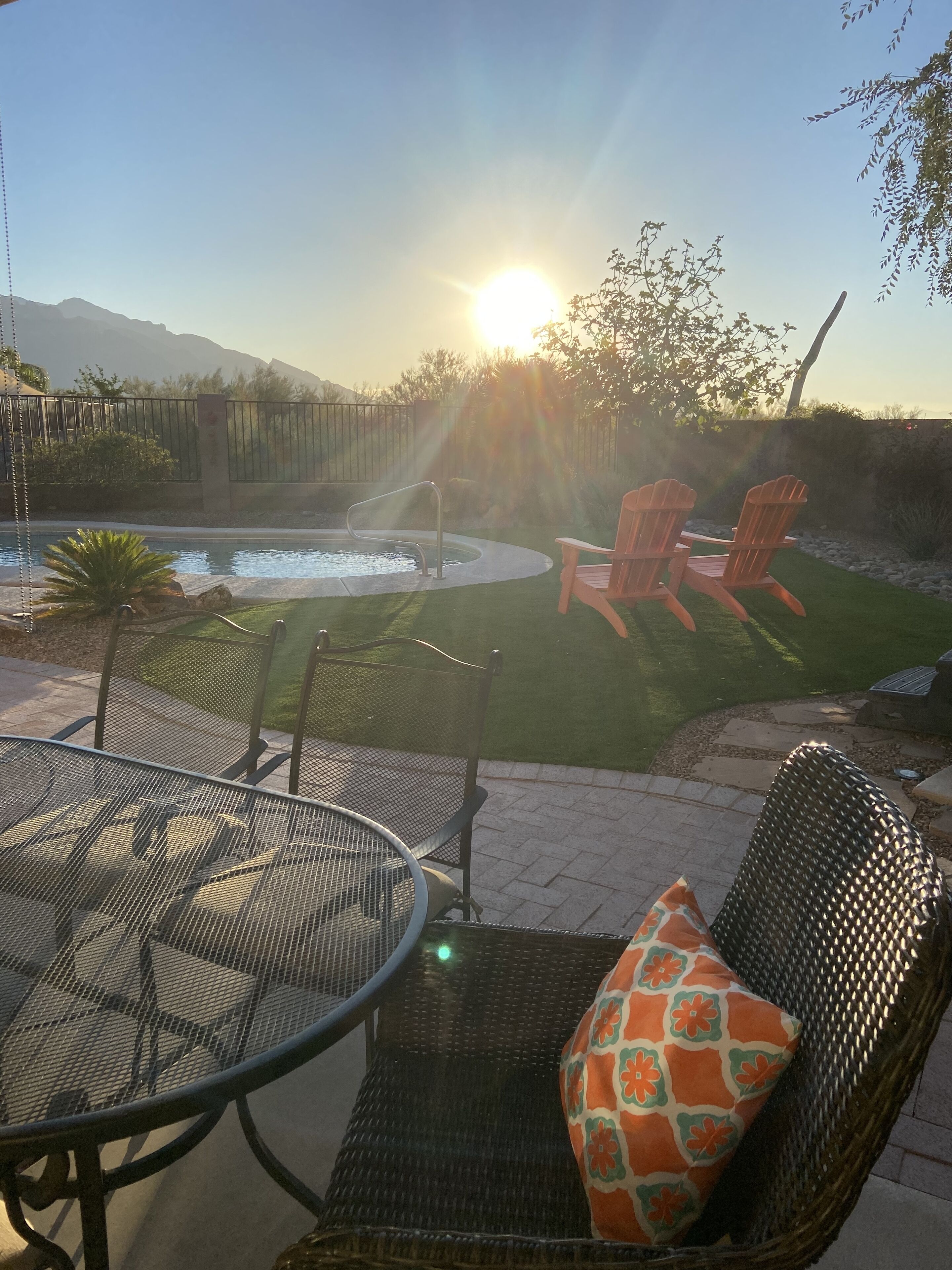 Eine Terrasse mit Pool, Stühlen und einem Tisch.
