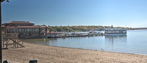 Un hôtel situé au bord de l’eau, doté d’une plage de sable, d’un quai et d’un bateau.