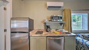 Eine kompakte Küche mit Kühlschrank, Mikrowelle und Kaffeemaschine.