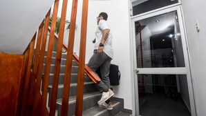 Une personne descendant un escalier en bois dans un bâtiment moderne.