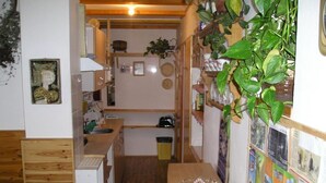 Una cocina estrecha con armarios de madera, un lavamanos y una pequeña mesa con un cuenco de vidrio.