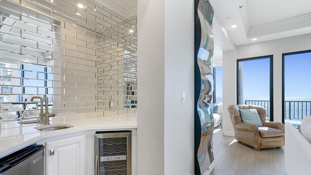 Una cocina moderna con armarios blancos, lavavajillas de acero inoxidable y salpicadero de azulejos.