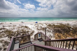 A beach with a wooden boardwalk leading to a dune area.