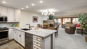 A spacious kitchen with white cabinetry, a granite countertop, and a built-in dishwasher.