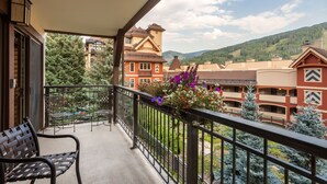 A balcony with a view of a building and mountains.