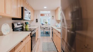 Une cuisine avec des meubles en bois, un réfrigérateur en acier inoxydable et un four à micro-ondes.