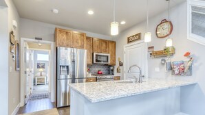 A modern kitchen with wooden cabinets, stainless steel appliances, and a granite countertop.