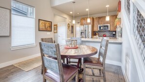 A modern kitchen with wooden cabinets, a stainless steel refrigerator, and a built-in oven.