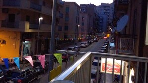 A balcony overlooking a street with parked cars and buildings. - B&B Salita Metello (Agrigento)
