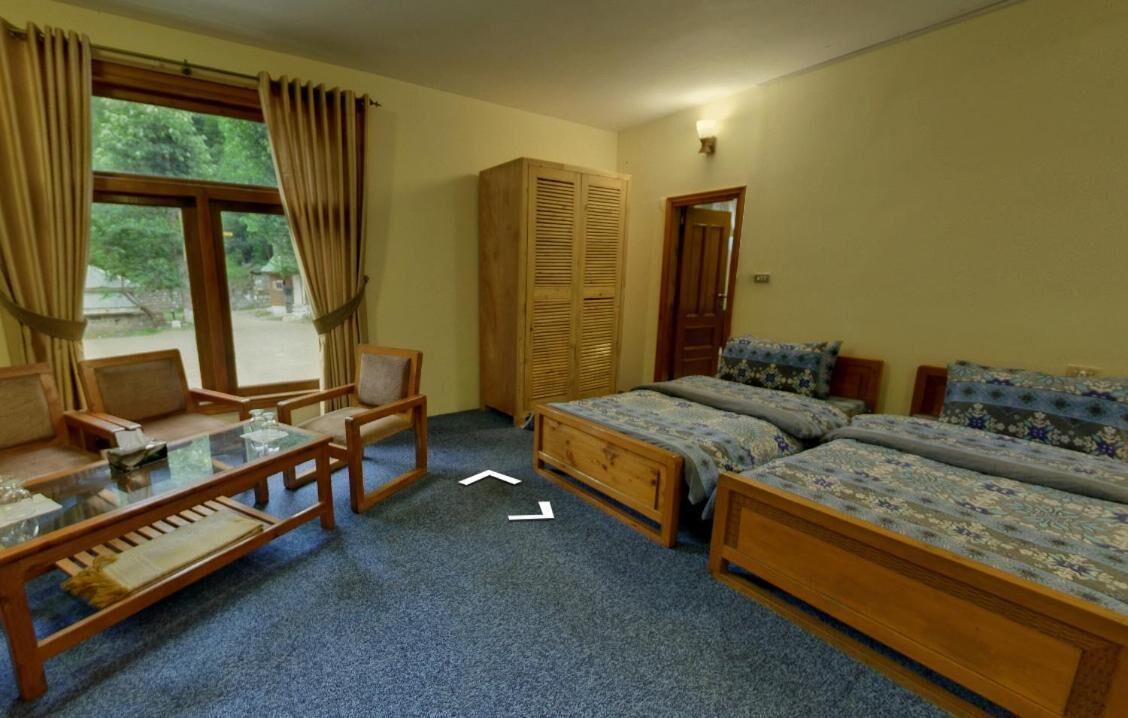 Un dormitorio con cama, escritorio, silla, armario y ventana con cortinas.