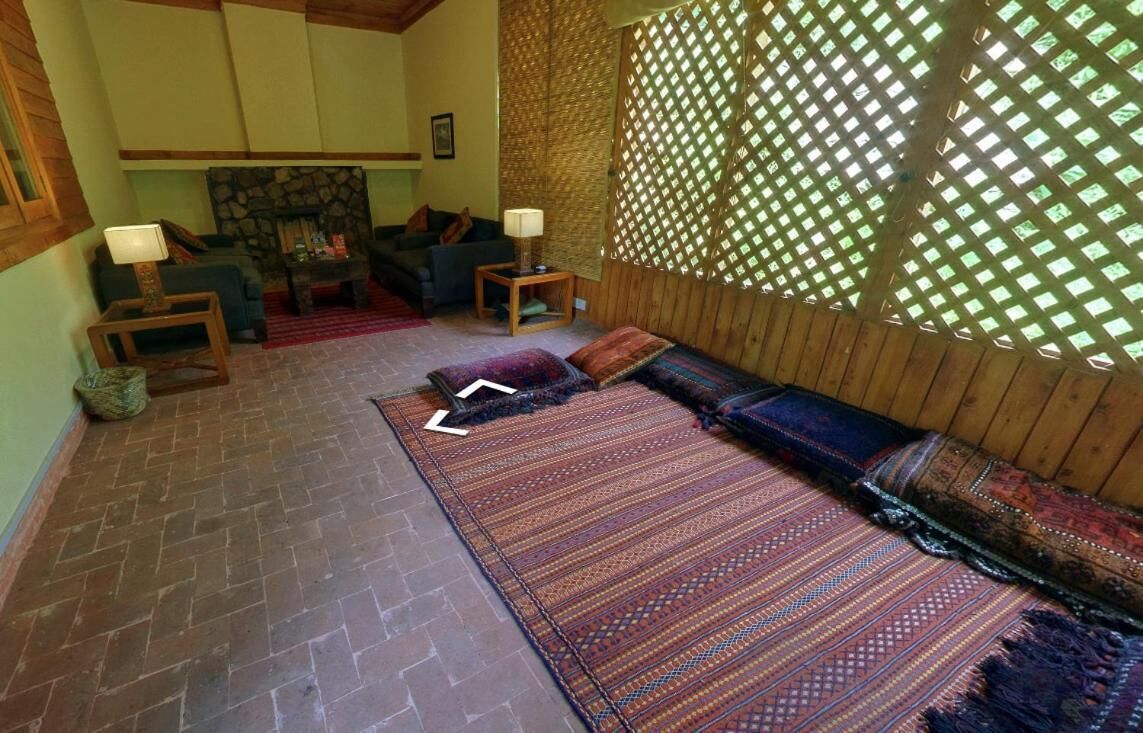 A cozy living room with a fireplace, two sofas, and patterned rugs.