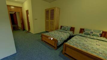 Un dormitorio con dos camas individuales, un armario de madera y suelo alfombrado.