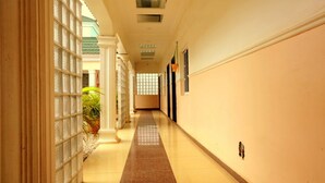 A long, narrow hallway with a tiled floor and a glass partition on one side.