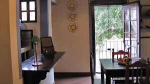 A dining area with a table, chairs, and a view through a door. - Casita Buena Vista (Antigua Guatemala)