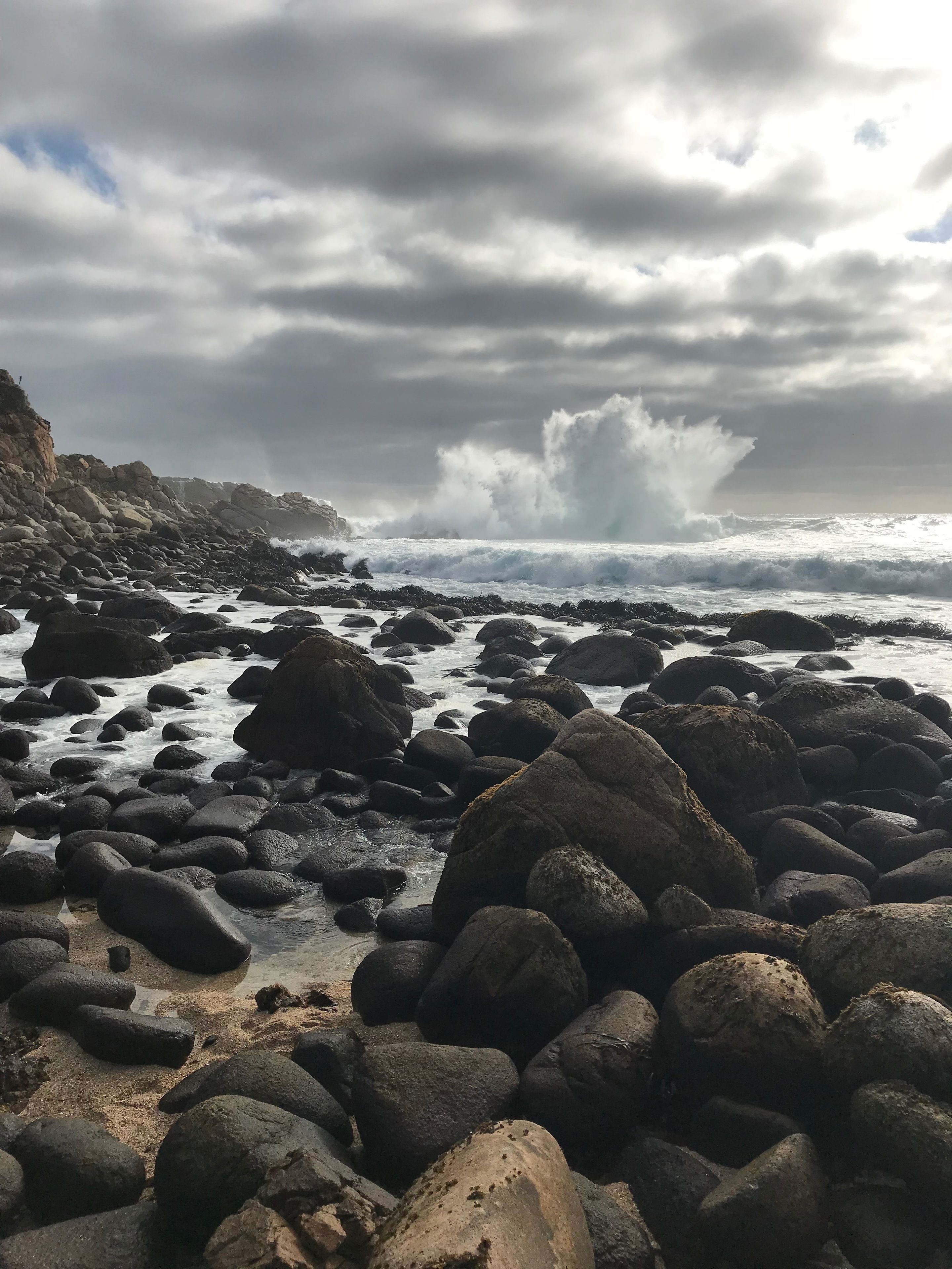 A rocky beach with waves crashing against the shore.