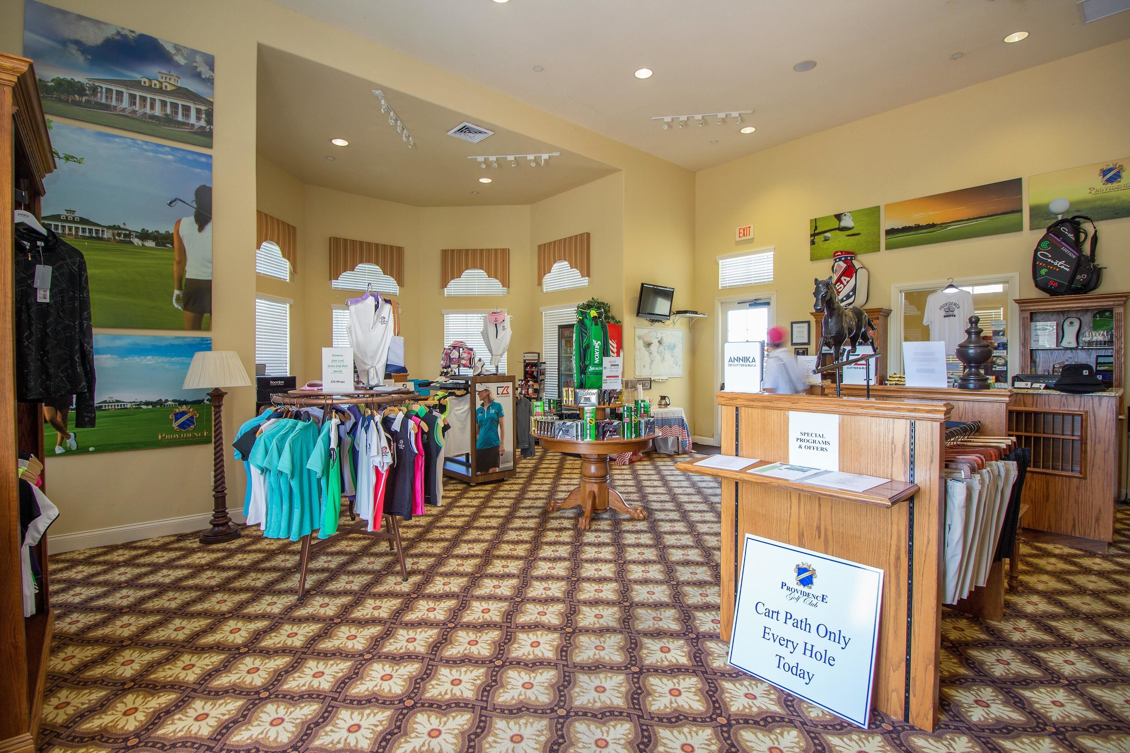 A golf-themed retail space with clothing racks, golf memorabilia, and a 'Cart Path Only' sign.