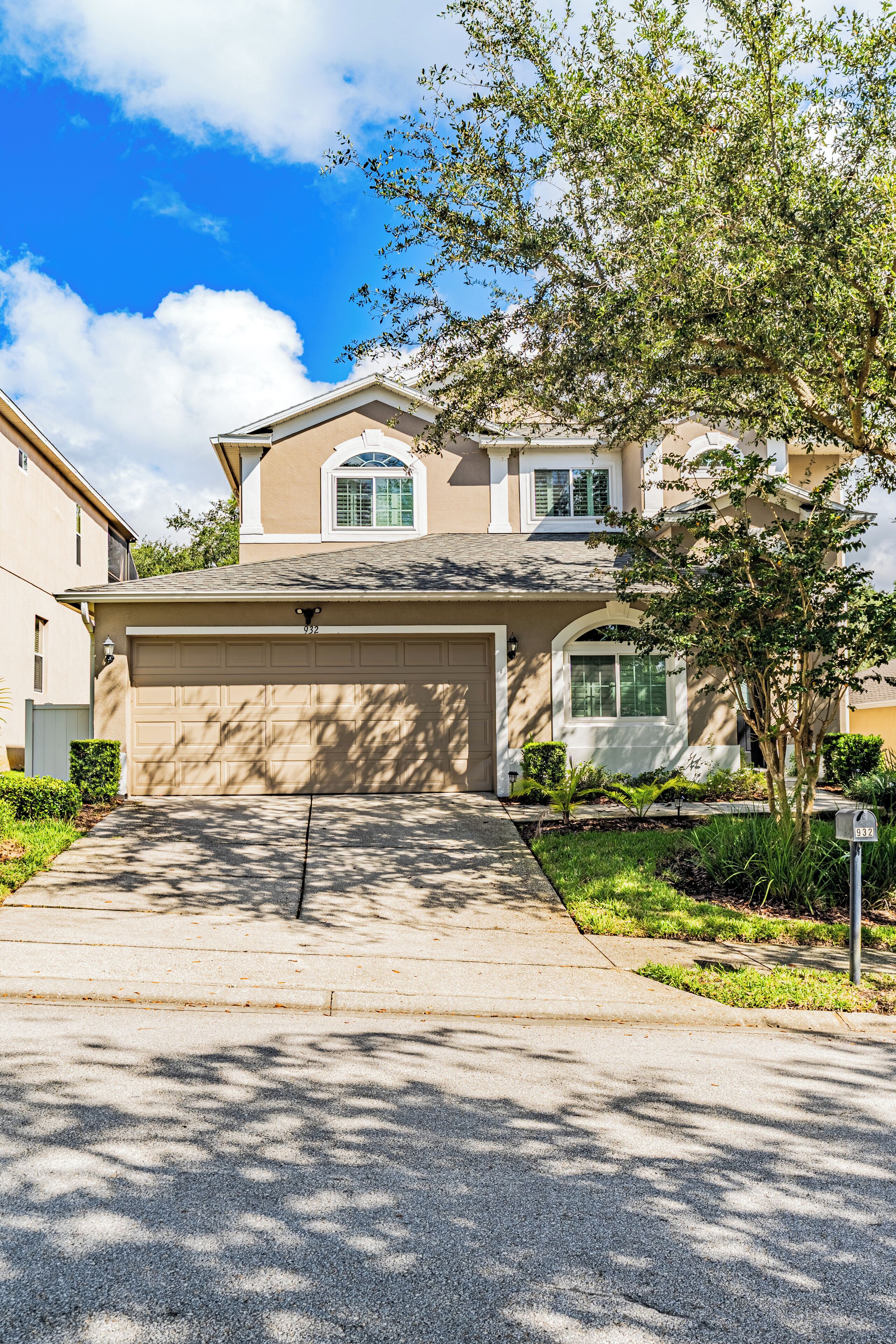 A residential house with a garage, a driveway, and a mailbox.