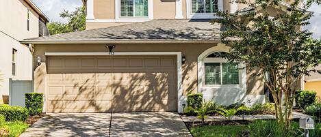 A residential house with a garage, a driveway, and a mailbox.
