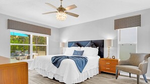 A bedroom with a bed, bedside tables, a chair, a ceiling fan, and a window. - Allamanda Holiday Home 4 Bedroom (Kissimmee)