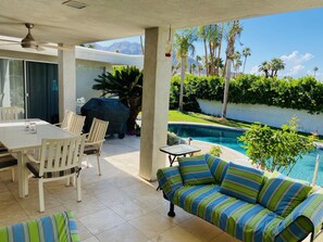 Relax by the pool with a meal at the outdoor dining table or unwind on the striped sofa.