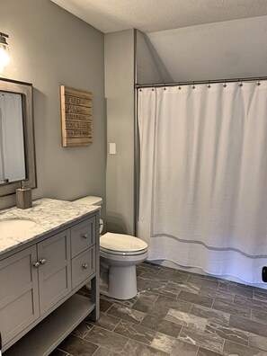 A bathroom with a marble sink, a toilet, and a shower curtain. - Updated, spacious, AC/FP, pool access, near Loon. C6901 by LRS (Lincoln)
