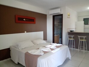 A hotel room with a bed, a small kitchenette, and a bathroom visible through an open door. - Marsallis Ponta Negra Hotel (Natal)