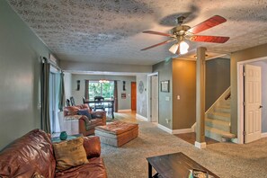 Relax in this stylish living area with a leather sofa, ottoman, and dining table.