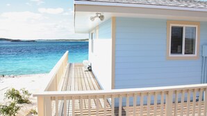 Una casa frente al mar con terraza de madera y vista al océano.