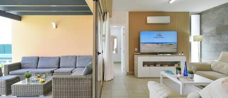 A modern living room with a sofa, two coffee tables, and a television.
